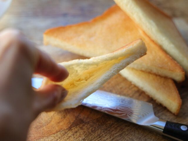 パンを斜めに切り、切り口に包丁で切れ込みを入れてポケットを作る。