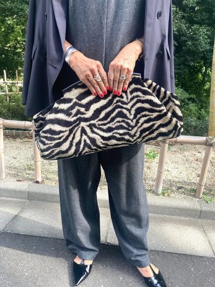 「『A VACATION』のPILLOW ZEBRAバッグはジャガードのゼブラ柄が印象的な立体感のある大きなクラッチ。手に抱えた姿も様になるところがお気に入りです。靴は『L.』のTストラップを合わせました。歩くたびに裾からのぞくストラップがかわいいですよね」