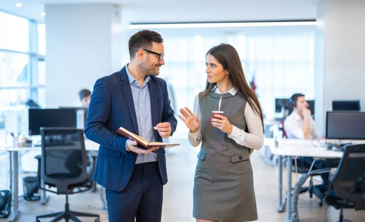 オフィスを歩きながら話す男女