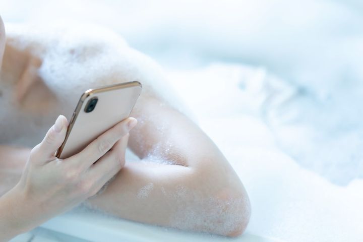 お風呂でスマートフォンをいじる女性の手元