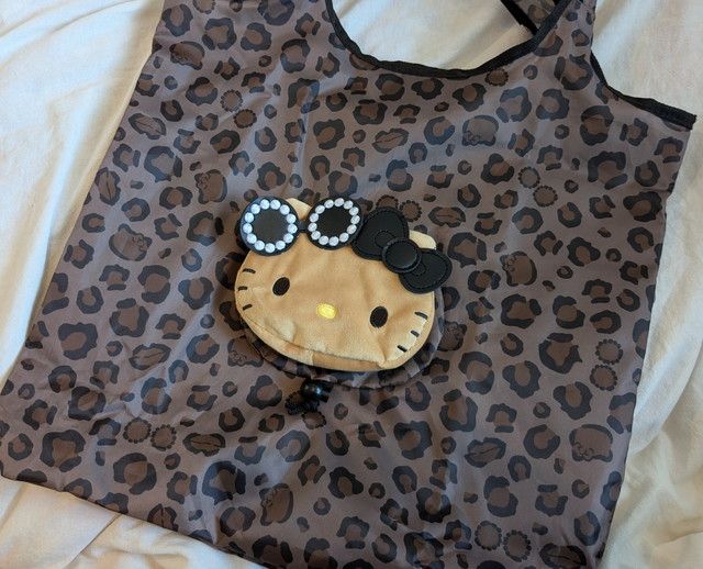 ヒョウ柄ビッグバッグの全体と、中央に付いた日焼けキティのぬいぐるみ
