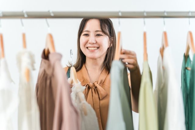 洋服を選ぶ笑顔の女性