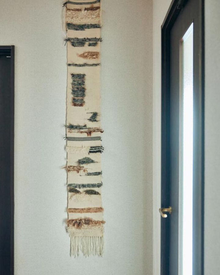 卓上の織り機でつくったタペストリーは玄関の飾りに。「縦糸は100円ショップで購入した糸なんです」