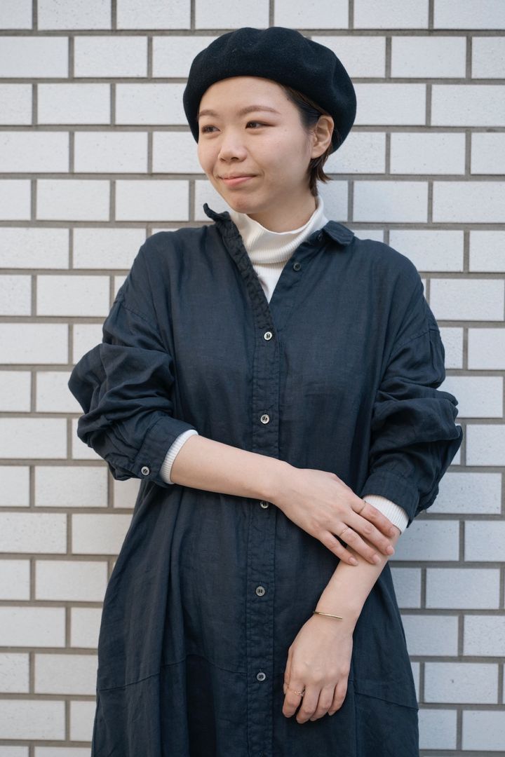 リネンワンピースに白のタートルネックカットソーを重ねた首もとレイヤードの上半身スタイル