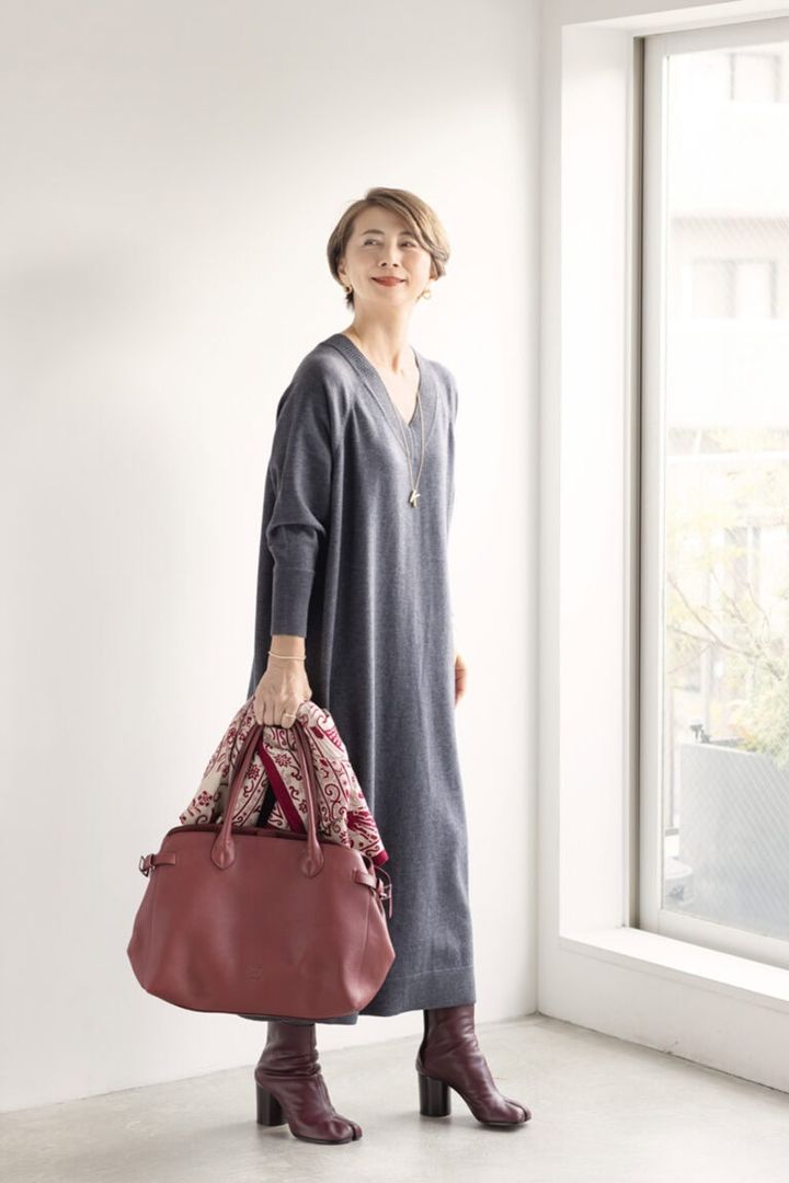 潔いシンプルさで着る人の個性を引き立ててくれるニットワンピース。「温かみのあるゴールドアクセサリーがアクセント役に」