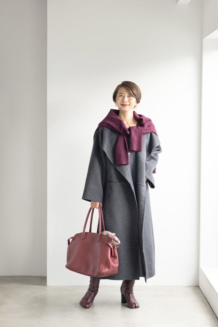 コート／トーテム、ワンピース／マイカ＆ディール、肩がけしたニット／ネミカ、ピアス／ザラ、ネックレス、ブレスレット、リング／すべてイシス、バッグ／ヒロフ、手に持ったストール／エルメス、ブーツ／メゾン マルジェラ（すべて私物）