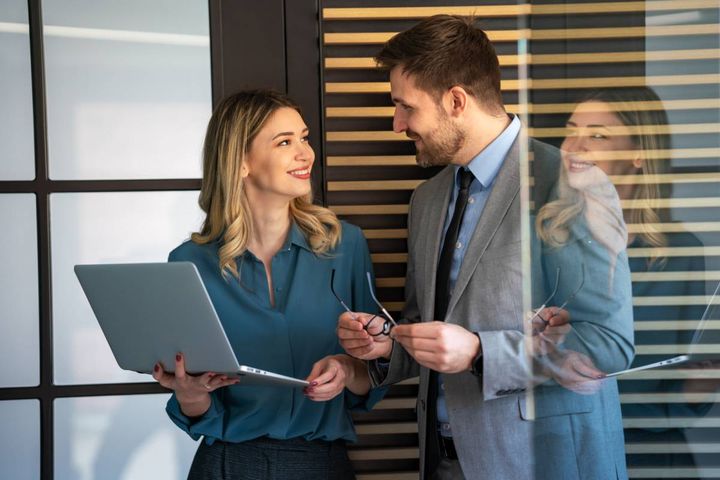 パソコンを持つ女性と話す男性