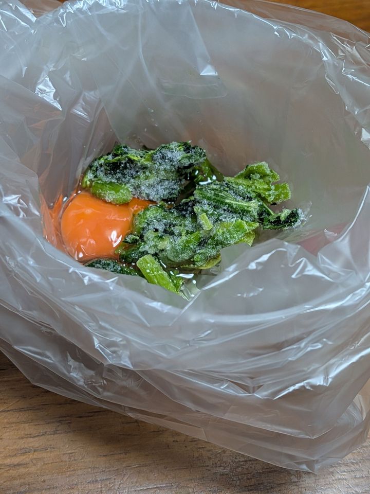 2．アイラップに卵をわりいれ、冷凍ほうれん草を入れる。軽く混ぜ合わせる。