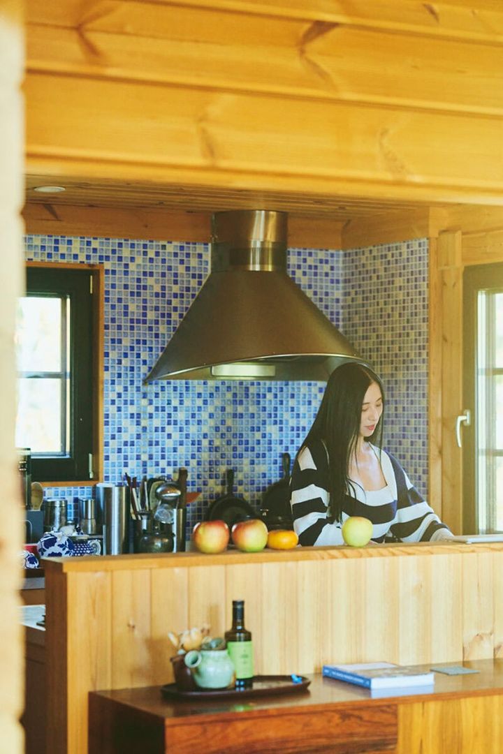 小さな青いタイルのグラデーションが可愛らしい三浦家のキッチン。 旬のリンゴは香りを楽しむためにカウンターに並べて。