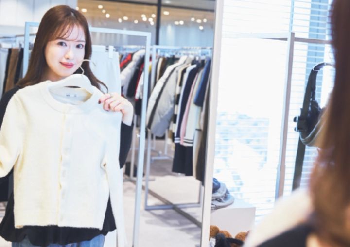 パフニットクルーネックカーディガンを持った塩島さん