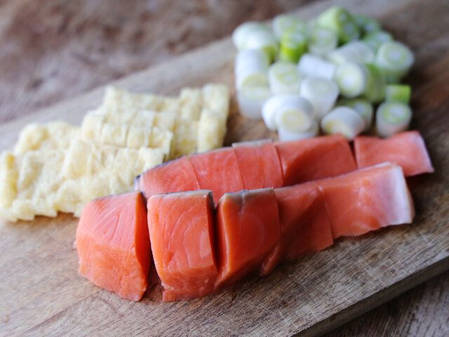 鮭はひと口大に、長ねぎは1～2cmの小口切りにし、油揚げは横半分に切ってから1.5cmほどの幅に切る。