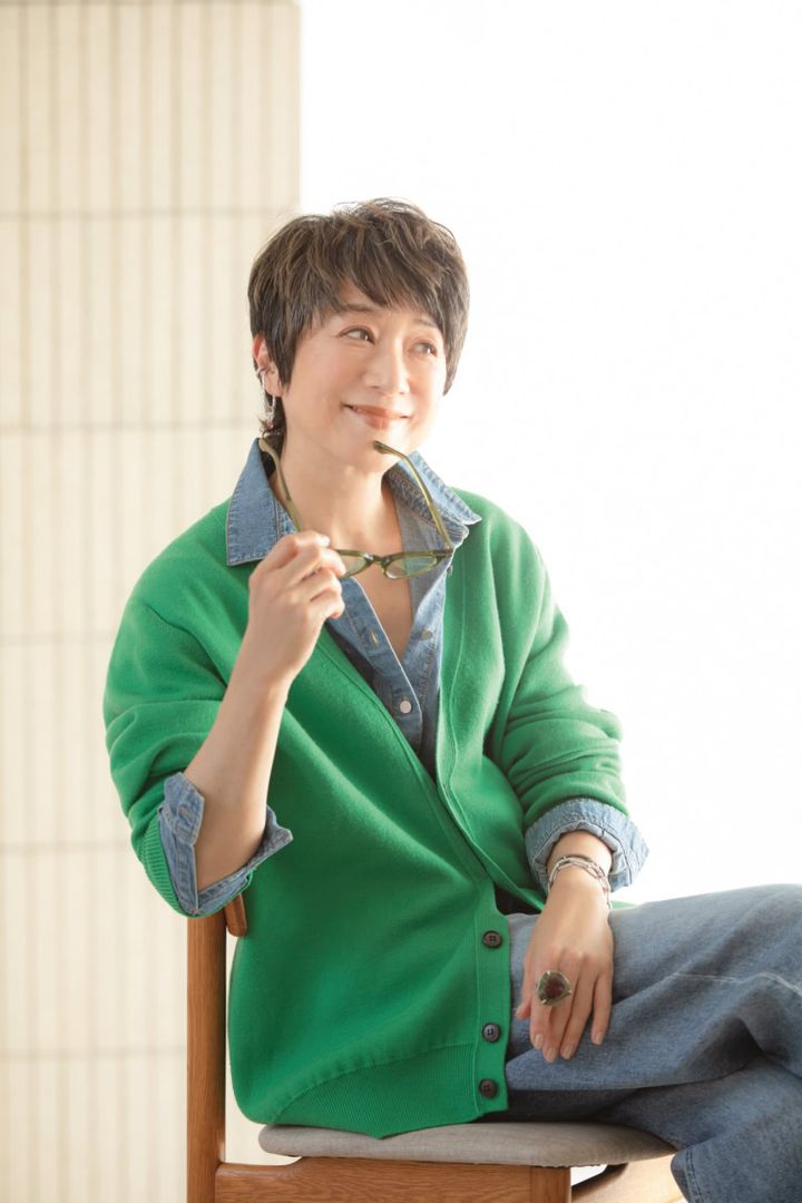 カーディガン¥39,600／スローン（ザ ショップ スローン 神戸）、デニム¥31,900／ヤヌーク（ カイタックインターナショナル）、メガネ¥42,900／アイヴァン（ アイヴァン東京ギャラリー）、イヤーカフ¥49,500、チャーム¥38,500、チェーンブレスレット（大）¥198,000、チェーンブレスレット（小）¥187,000、リング¥1,870,000／すべてボン マジック、シャツ／スタイリスト私物