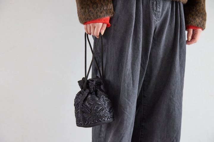 主張しすぎないビーズ装飾をあしらった黒の巾着型バッグ