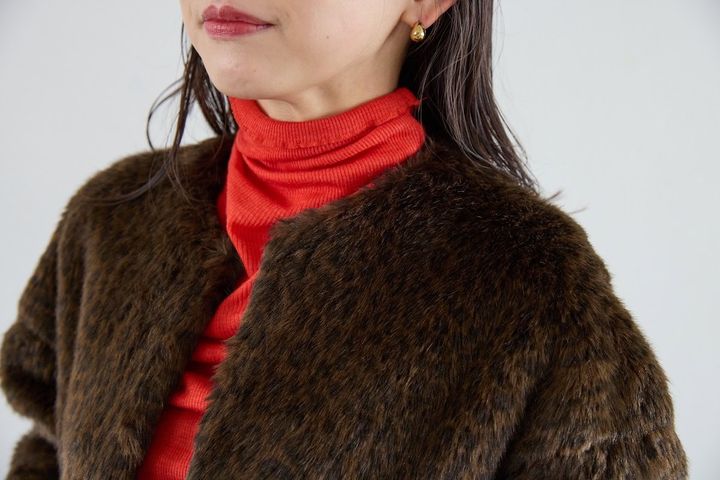 リアルな質感のレオパード柄クラフトファーショートコートと、赤のウールシルクのボトルネックプルオーバーのレイヤード