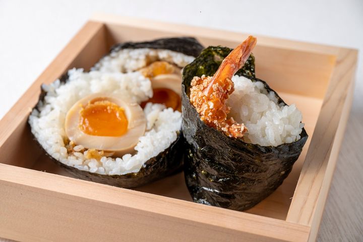 星野本店の刻みをトッピングした煮卵入り「摂田屋くろ助」500円と、浪花屋製菓の柿の種を衣に加えた「摂田屋天むす」500円