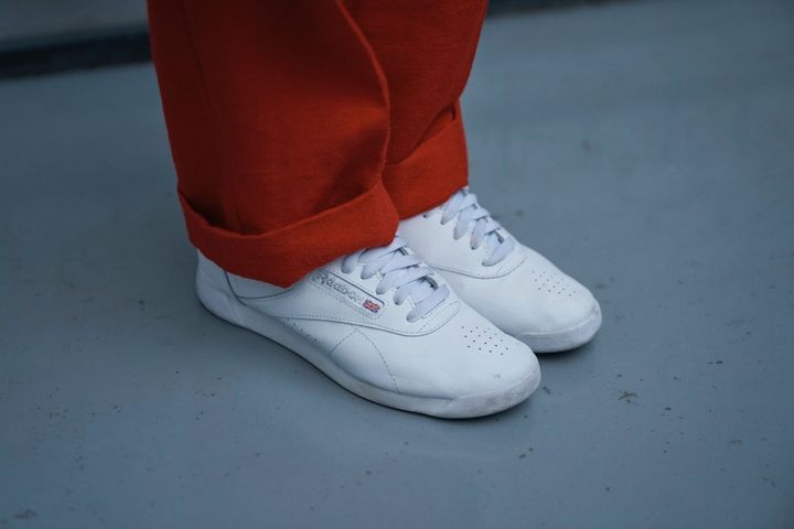 赤いパンツに合わせた、冬の着こなしを軽やかに仕上げる、リーボックの白スニーカー