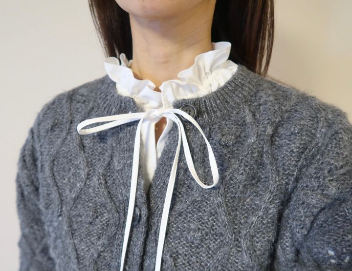 首もとのボタンを開けたカーディガンと合わせてもよし