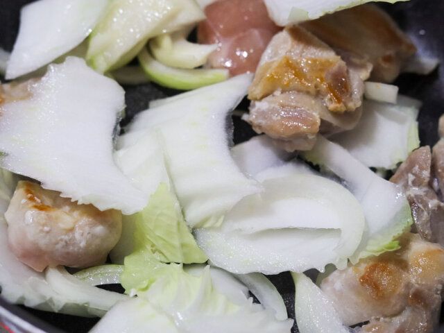 鶏肉にこんがり焼き色がついたら、鶏のうま味を野菜にからめながら白菜の芯、たまねぎを加えて1～2分炒める。