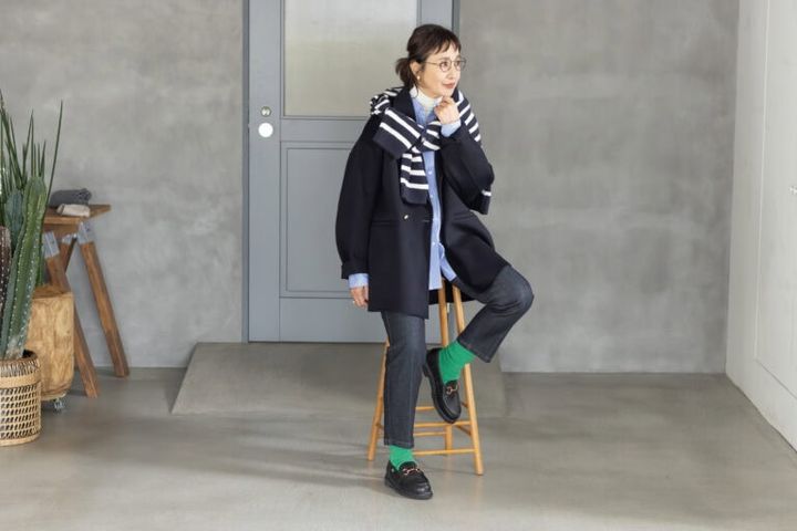 靴下¥9,900／スローン（ザ ショップ スローン 神戸）、コート¥55,000／ハウント/ハウント代官山、肩にかけたカーディガン¥13,200／ステートオブマインド（ともにゲストリスト）、タートルネック¥2,290／ユニクロ、シャツ¥53,900／エブール（リトルリーグ インク）メガネ¥50,600／アイヴァン（アイヴァン東京ギャラリー）、イヤリング¥11,000／アビステ、リング¥88,000／ピモンテ、靴¥96,800／パラブーツ（パラブーツ青山店）