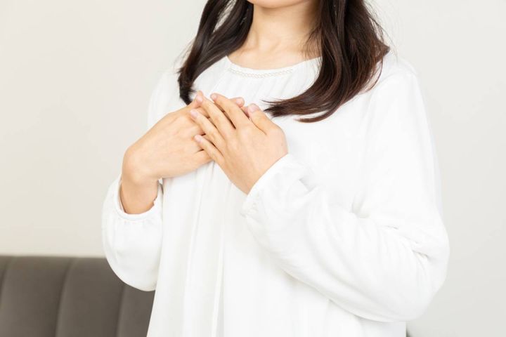 胸に手を当てる人