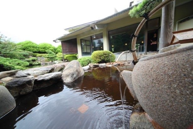 【写真】巨大な急須から露天風呂へお茶が注がれている 画像提供：和楽園