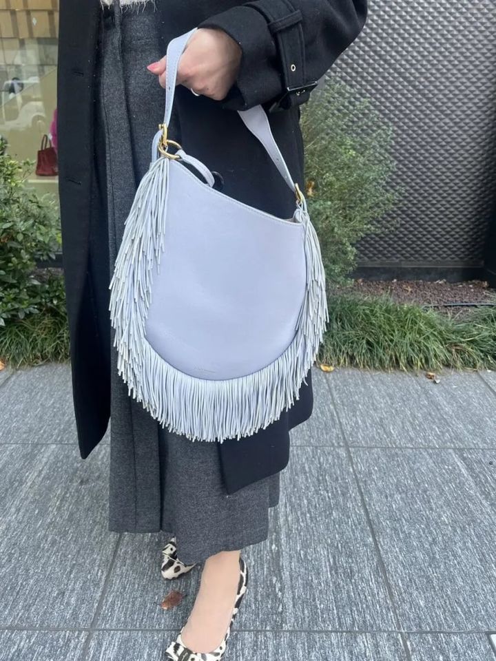 「J&M DAVIDSONで人気の巾着バッグを買いに行くつもりが、斜めがけにもハンドル持ちもできて、かしこまった場だけでなくカジュアルなシーンにも使えると思って購入したバッグです。細かく繊細に揺れるフリンジがキレイで、コーデのアクセントとして投入しました」