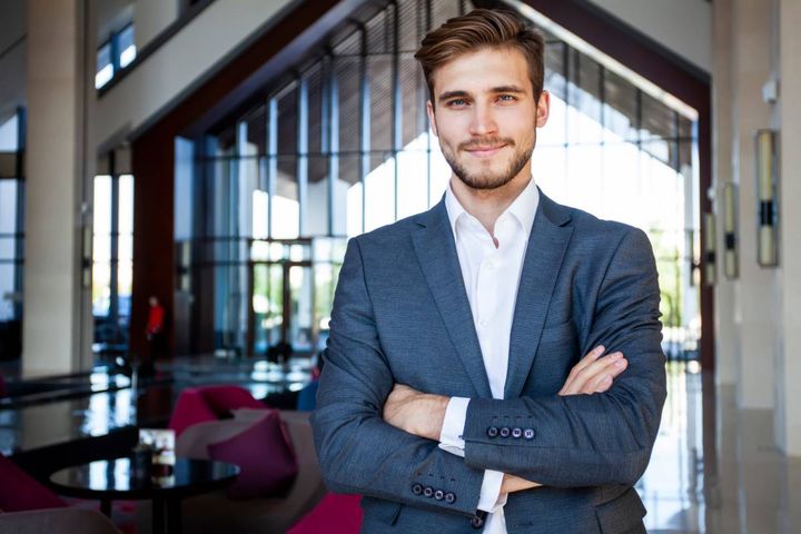 腕組みして立つ笑顔の男性