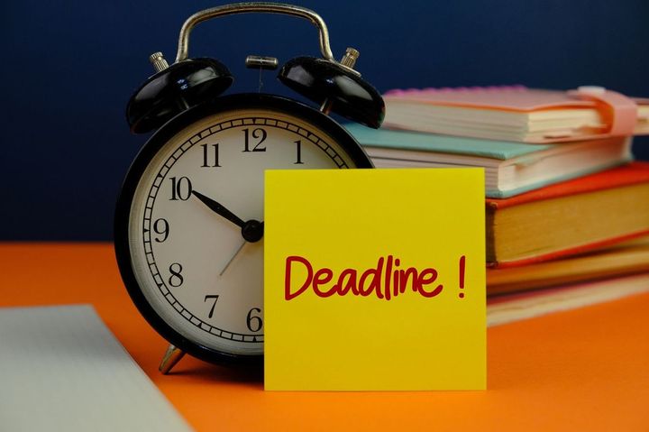 目覚まし時計に締切と書かれた付箋が貼ってある