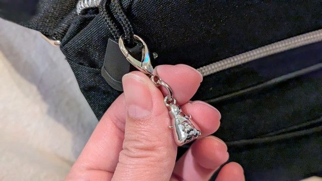 ショルダーバッグの金具部分アップ（カラビナと小さなシルバーチャーム）