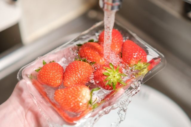 パックに水を入れていちごを洗う様子 イチゴ