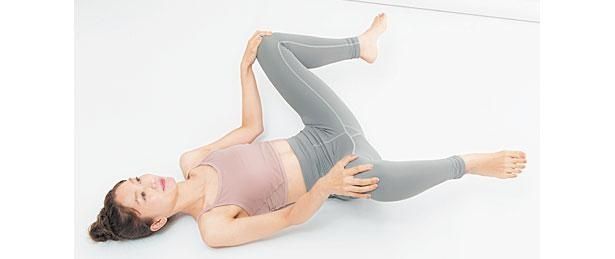 仰向けになり、ひざを閉じて上げ （C）erica／KADOKAWA