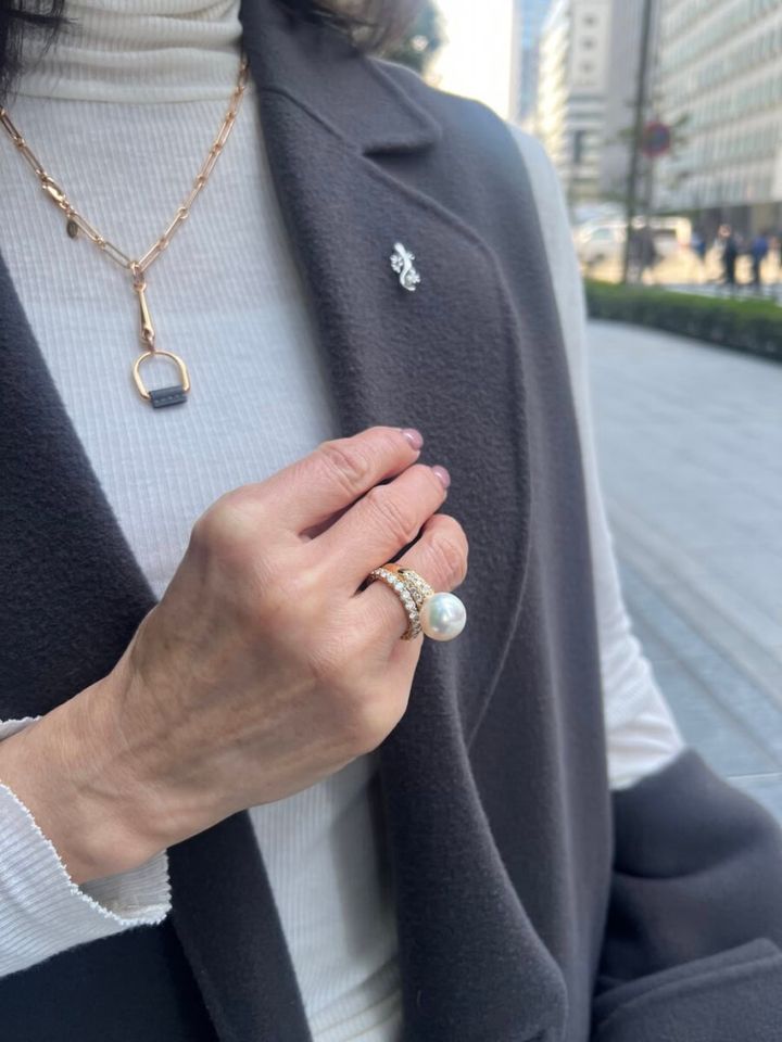 「コーデ全体はクールな雰囲気にしたので、華やかなアクセサリーでエレガントな雰囲気に。大人遊びを効かせたヤモリのピンブローチは小さなパールがついていて、大ぶりなパールのリングとリンク。ゴールドのネックレスは、トップにグレーのレザーがあしらわれているので、ジレ＆コートやバッグとリンクさせ、コーディネートに統一感を持たせています」