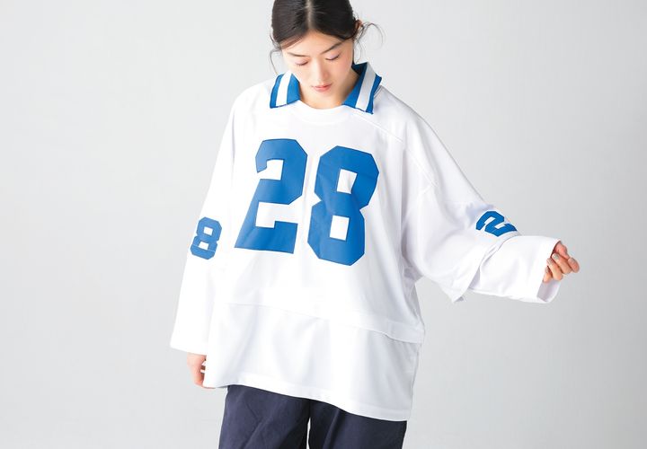 ’90sデッドストックのフットボールジャージーをリメイクした別注トップス。袖と身頃の切り替え部分に施されたファスナーを外すと七分袖＆クロップド丈に。