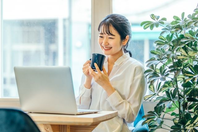 パソコンの前で笑顔の女性
