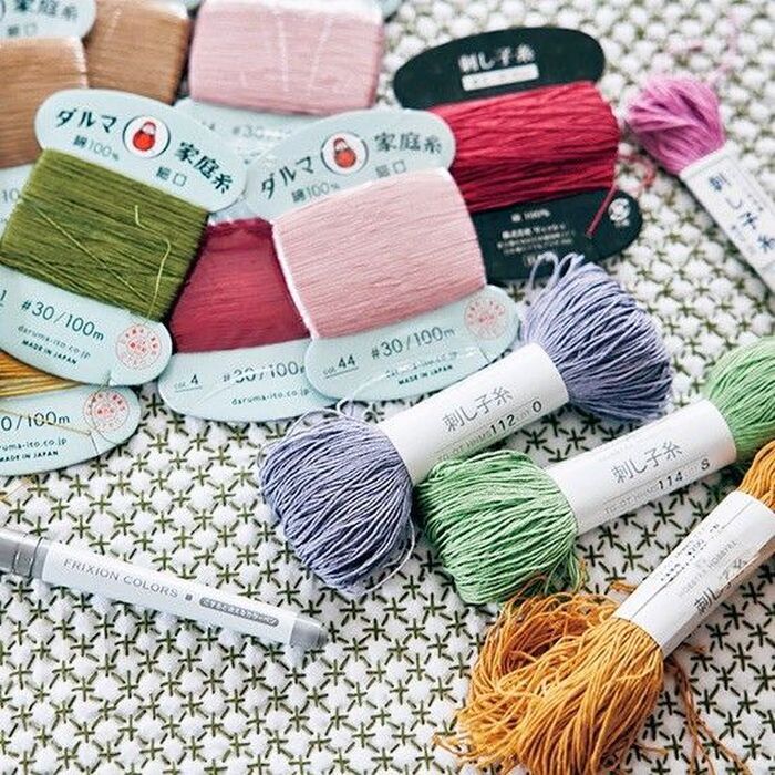 刺し子糸や木綿糸、家庭用手芸糸が並ぶ手芸道具セット。色とりどりの糸と下絵が描かれた刺し子布。伝統柄の意味や糸選びを楽しみながら刺し子を楽しむ暮らし。