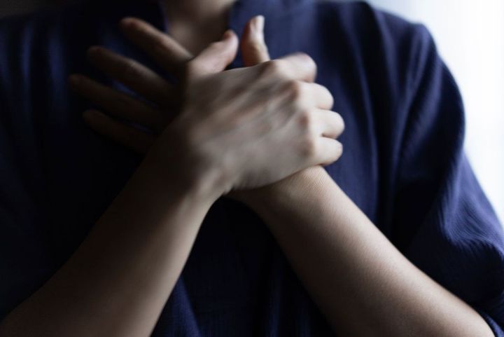 胸に手を当てる人