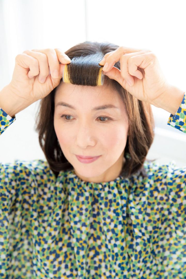 前髪をマジックカーラーで根元まで内巻きに。カーラーを外したらワックスをつけ、少し斜めを意識して毛流れをつける。