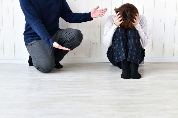 女性に文句を言う男性と、頭を抱える女性