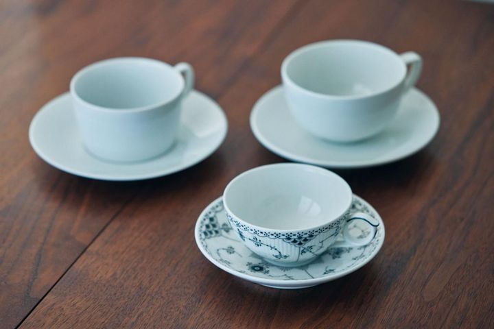 よく使うカップ。左上はポットとそろいの「マイセン」。右上は約25年愛用する「ロイヤルコペンハーゲン」。右下は心ときめいた同ブランドの新作、ブラックフルーテッド ハーフレース。