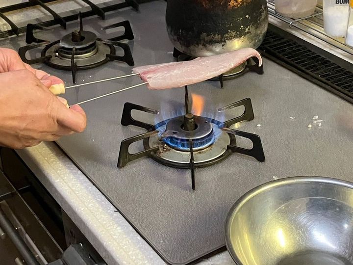 メジナの身を炙り中。串が2本しかなかったので縦に打ちましたが、本来は横に扇状に串を打つといい