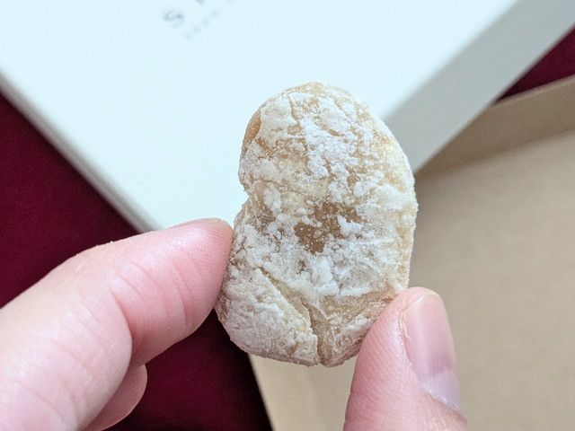 SHUKA「斗六豆」（白い結晶が付いた豆を指でつまんだアップ）