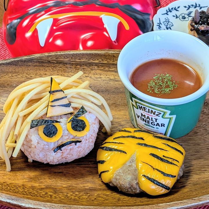 4.ご飯とケチャップを合わせておにぎりを作る。上に工程1のスパゲティをのせる。チェダーチーズと海苔で目と角と眉毛と口を作る