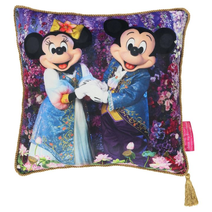 「ミッキーマウス」と「ミニーマウス」のシルエットの背景に色とりどりの花々が咲き誇るクッション