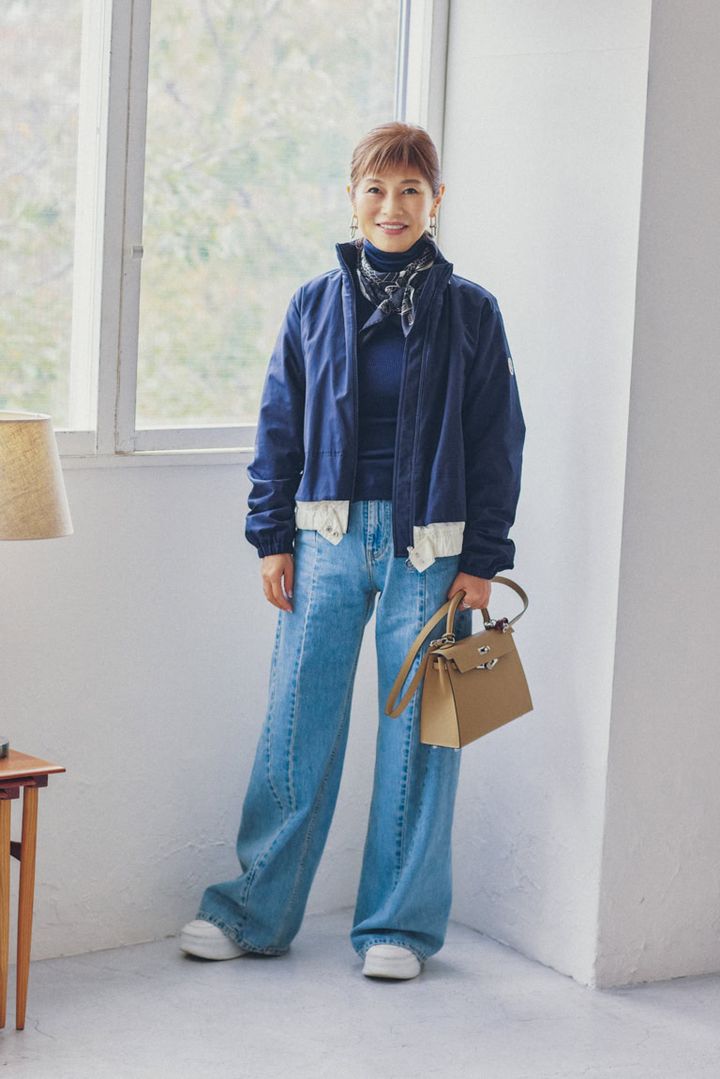 アウター／モンクレール、トップス／ユナイテッドアローズ、デニム／メゾン・マルジェラ、スカーフ、バッグ、リング左手／すべてエルメス、スニーカー／セリーヌ、ピアス／ティファニー、時計、リング右手／ともにシャネル（すべて私物）