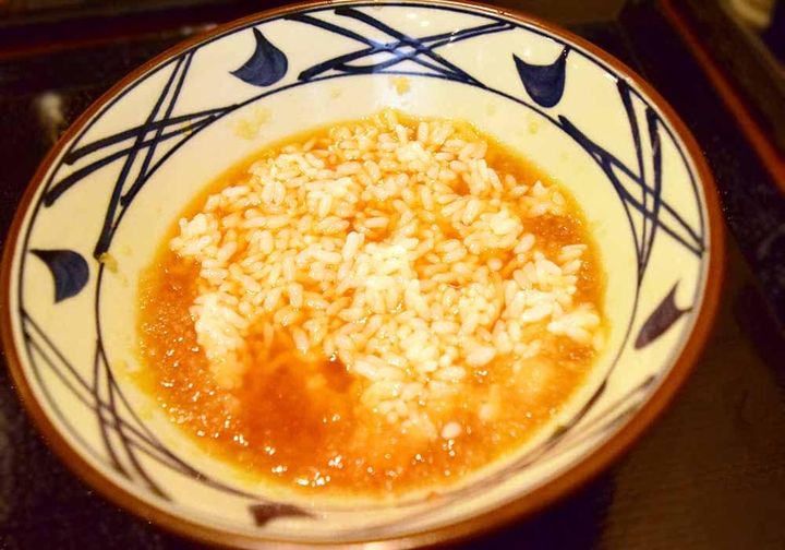 うどんを食べ終えたら、白ご飯をうどんつゆに入れてよく混ぜます。