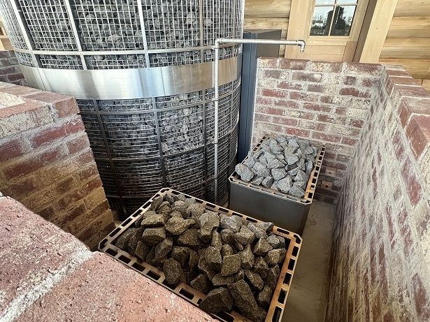 大きなサウナストーブの脇に熱源となるサウナストーブがある