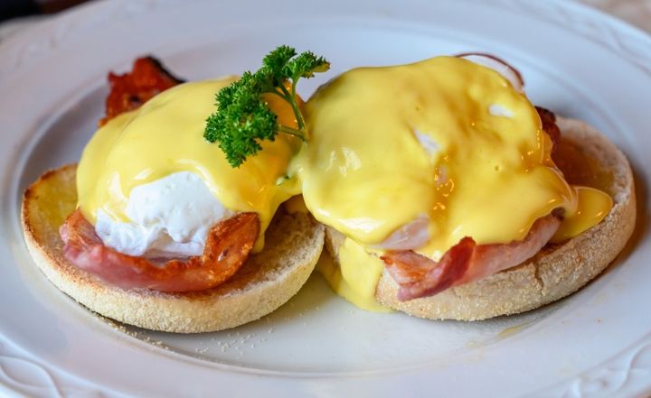 Weekend brunch in Scotland with two eggs benedict on homemade muffuns with roasted bacon and yellow hollandaise sauce. スコットランドの週末ブランチ。自家製マフィンにのせたエッグベネディクト2皿、ローストベーコンと黄色いオランデーズソース添え