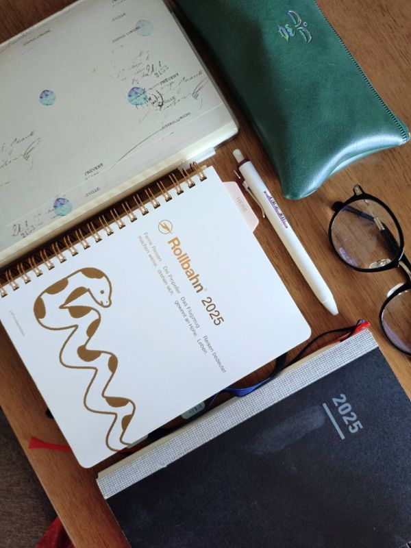 机の上に並ぶ手帳やメガネ