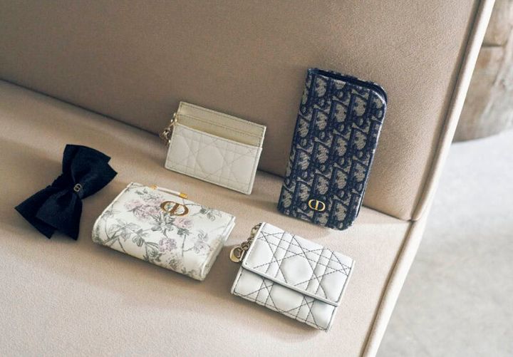 上段右から、“ディオール オブリーク”ジャカードを使用した手帳型。内側にはカード入れやポケットもあって機能的。スマホケース※iPhone16 Pro用￥97,000、アイボリー×ゴールドの洗練された配色と“カナージュ”ステッチが上品。取り外し可能な“D.I.O.R.”チャームも華やか。カードケース［H8×W10.5×D0.5、カード入れ5］￥65,000、下段右から、白×黒のコントラストがスタイリッシュ。コンパクトな三つ折りで手のなじみもグッド。日本限定。ウォレット［H8.5×W10×D2.5、カード入れ4］￥110,000、ムッシュのお気に入りの花を繊細なタッチと優しい色合いで描いたファンタジックなデザイン。日本限定。ウォレット［H9×W12×D2、カード入れ6］￥125,000、大きなリボンと“CD”シグネチャーを優雅なアクセントに。ヘアアクセサリー￥68,000（すべてディオール／クリスチャン ディオール）