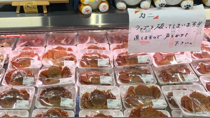 スーパーや鮮魚店のショーケースに、整然と並ぶカニのパック。しかし、岩手県陸前高田市の「荒木鮮魚店」で、そんな常識を覆す光景が目撃されました。なんと、パッキングされたはずの毛ガニたちが、次々と「脱走」を図っているのです。